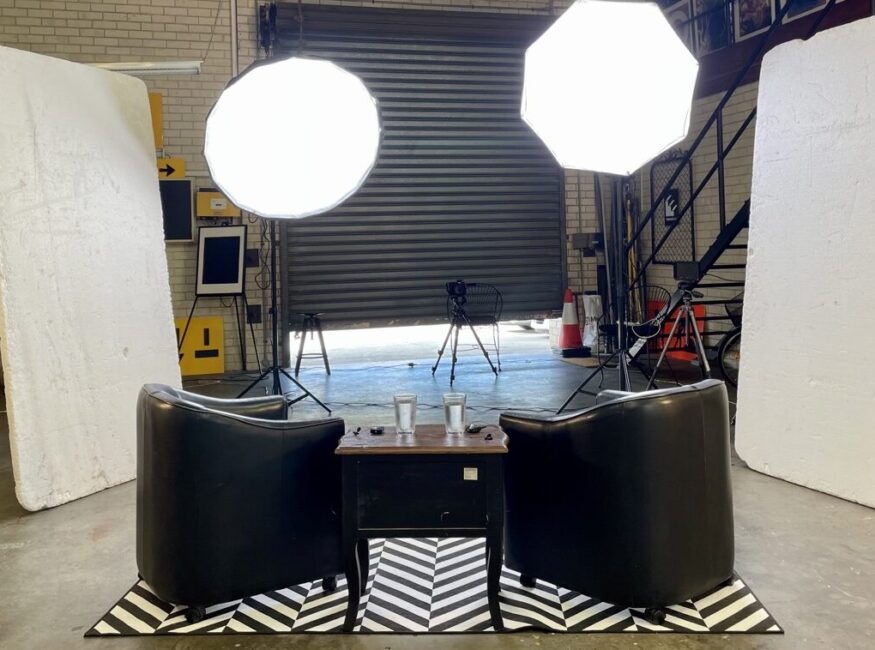 Cameras with studio lights and two armchairs
